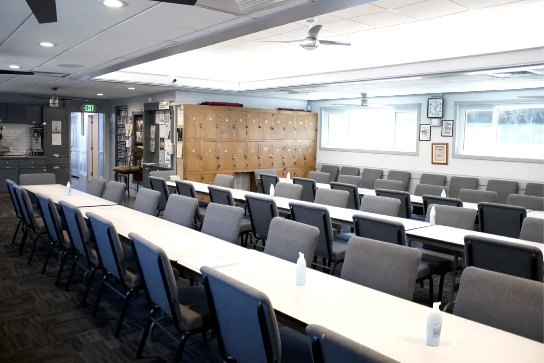 A well-lit room with a long table, chairs